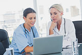 Two women doctors working on a laptop