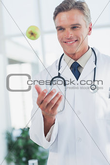 Doctor throwing a green apple