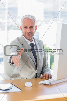 Smiling businessman reaching out for handshake