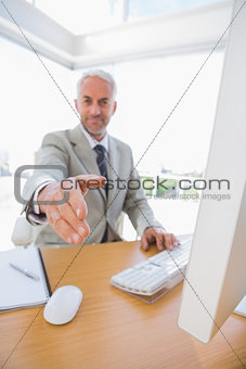 Cheerful businessman reaching hand out for handshake