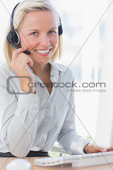Businesswoman using headset and smiling at camera