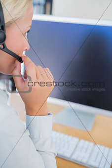 Businesswoman with headset looking at computer
