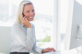 Young businesswoman on the phone smiling at camera