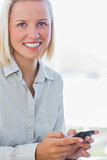 Blonde businesswoman texting and smiling