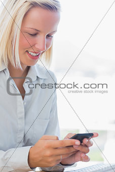 Businesswoman texting and smiling