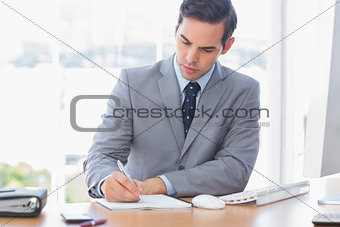 Businessman writing at his desk