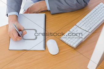 Businessman writing on blank notepad