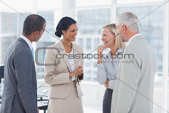 Happy business team chatting and laughing