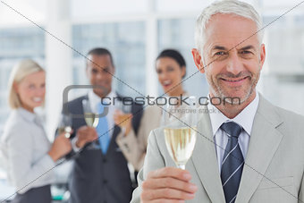 Businessman smiling at camera with champagne