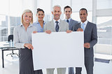 Business team holding large blank poster