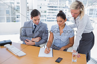 Businesswoman showing colleagues something on her notepad