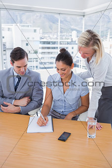 Happy businesswoman showing colleagues something on her notepad