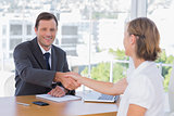 Smiling businessman shaking hand of a job applicant