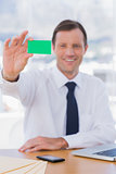 Cheerful businessman holding a green business card