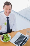 Overhead of a smiling businessman eating a salad