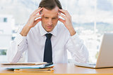 Worried businessman holding his head