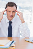 Stressed businessman holding his head