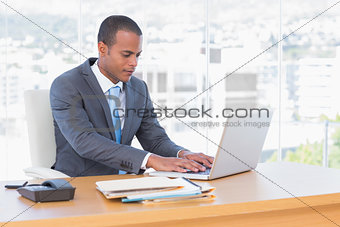 Handsome businessman working at his laptop