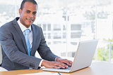 Cheerful businessman working on his laptop