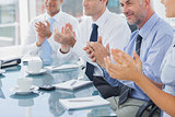 Group of business people clapping together
