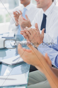 Business people clapping together