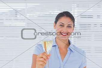 Brunette businesswoman raising a glass of champagne