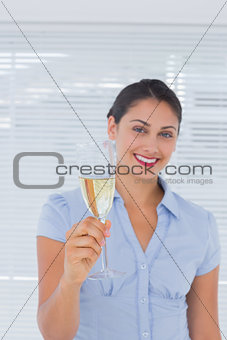 Attractive businesswoman holding champagne
