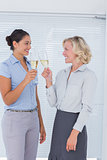 Two colleagues toasting with champagne