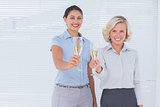 Coworkers holding flutes of champagne