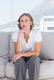 Thinking businesswoman sitting on couch