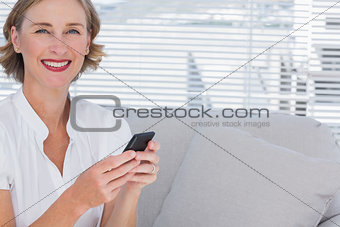 Smiling businesswoman using her mobile phone