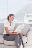 Cheerful businesswoman relaxing and reading newspaper