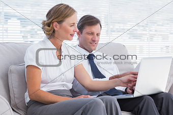 Business people watching something on laptop