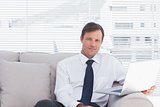 Cheerful businessman sitting on couch