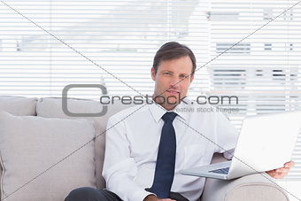 Cheerful businessman sitting on couch
