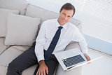 Smiling businessman with a laptop