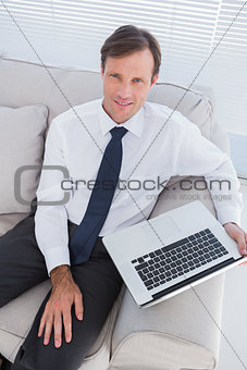 Portrait of handsome businessman sitting on couch
