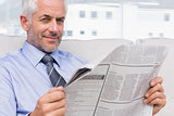 Smiling businessman holding a newspaper
