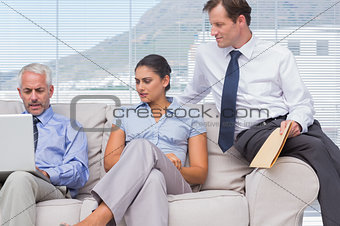 Businesspeople looking at colleagues laptop