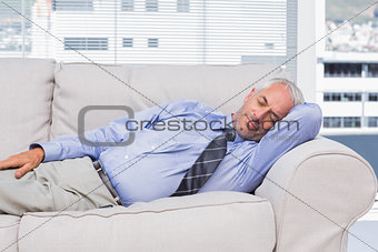 Businessman lying on sofa asleep