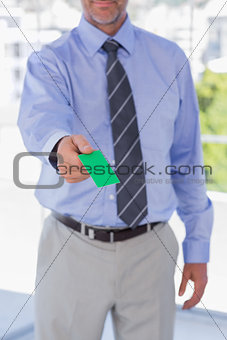 Businessman giving green business card