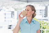 Businesswoman drinking from disposable coffee cup