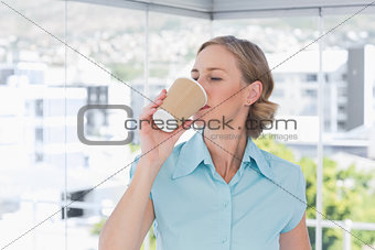 Businesswoman drinking from disposable coffee cup