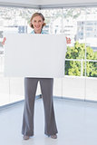 Smiling businesswoman holding large white poster