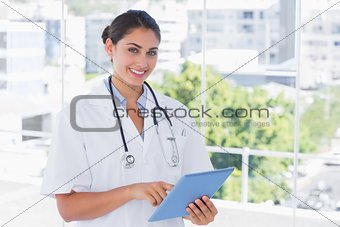 Happy young doctor using tablet pc