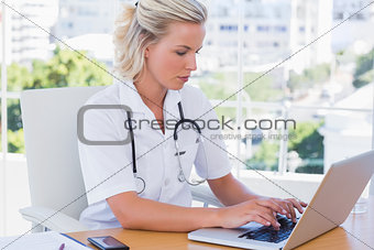 Nurse in her office working on her laptop