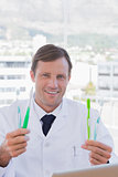 Cheerful doctor holding two toothbrushes