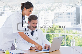 Group of doctors working together on a laptop