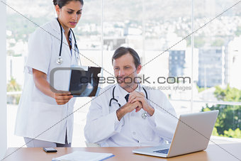 Pretty doctor showing a x ray to a colleague