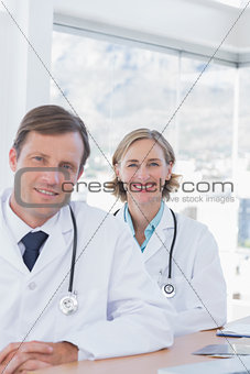 Smiling group of doctors posing at their desk